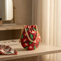 Red-orange floral potli bag with drawstring