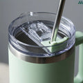 Sage green straw travel cup with handle